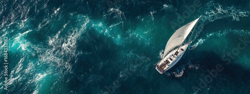 High-angle view of a sailboat navigating choppy waters