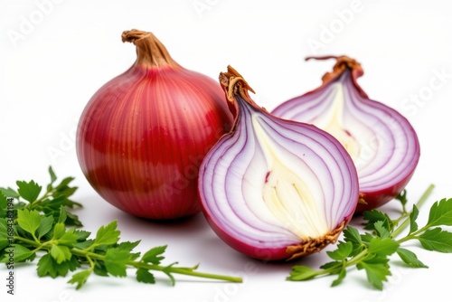 Fresh red onions with white and purple interior halves and green herbs on a clean white background for healthy cooking fresh vegetable ingredients