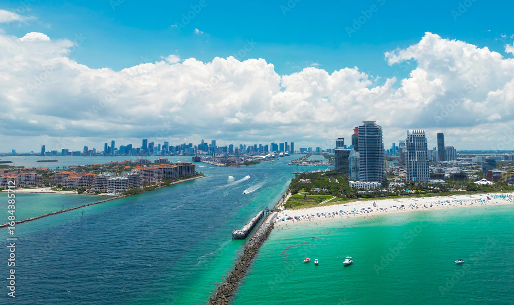 Fototapeta premium Aerial view of Miami Beach with turquoise waters. Drone shot of Miami skyline. Top view of South Beach. Miami cityscape with luxury skyscrapers and ocean. View of Miami famous coastline.