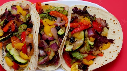 Three veggie tacos filled with roasted peppers, onions, and zucchini