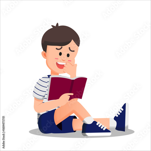 A boy sits on the floor reading a book with a shy smile