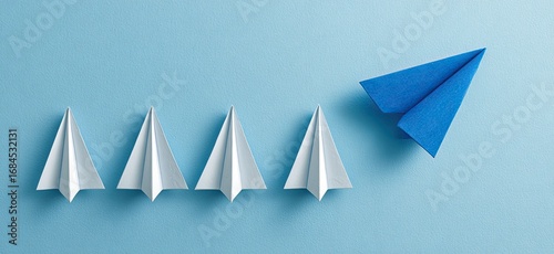 Four white paper airplanes and one blue paper airplane on a light-blue background