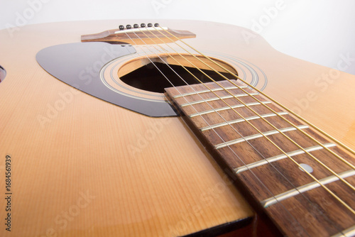dreadnought six-string guitar made of light wood on a white background. an isolated object. close-up. with a place for the text.