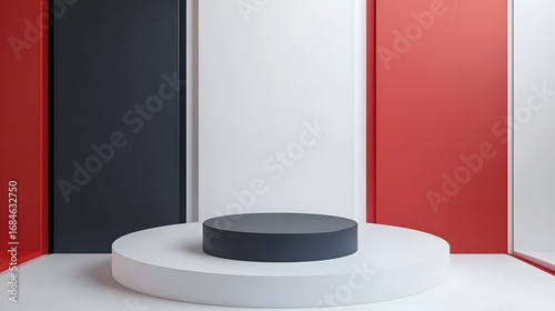 Dark gray round product display platform contrasts against a backdrop of red white and black panels.