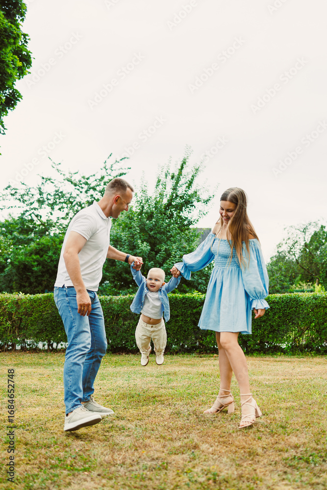 Obraz premium A Joyful Family Moment Picture a scene where loving parents are having a wonderful time playing with their adorable child in a beautiful, lush green park filled with vibrant nature all around