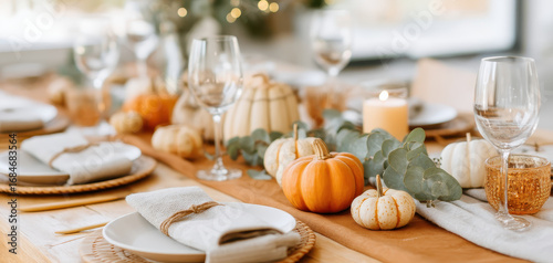 Autumn table setting with pumpkins and candles creates warm thanksgiving dinner atmosphere with fall decorations and elegant rustic style for family gatherings