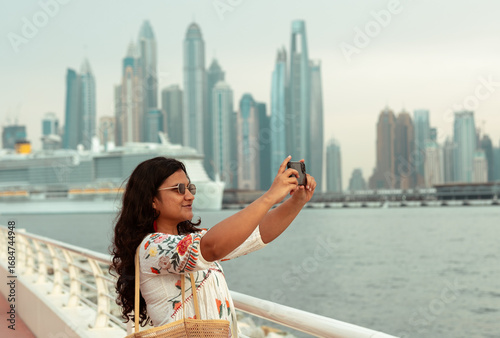 Canvas Print woman taking photos on her trip to Dubai Marina, young woman solo traveling in