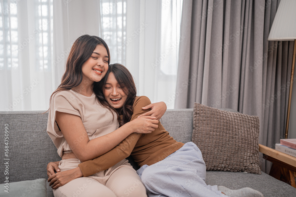 Obraz premium Two smiling friends joyfully embrace each other while they relax together on a cozy couch