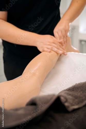 Wallpaper Mural Professional massage therapist performing leg massage in spa Torontodigital.ca