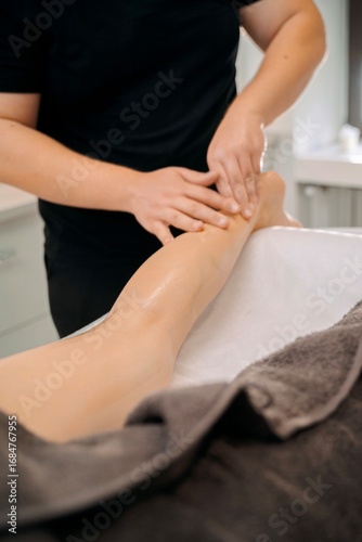 Wallpaper Mural Professional massage therapist performing leg massage in spa Torontodigital.ca