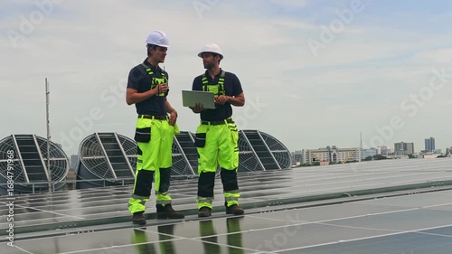 Team male engineers installs solar panels renewable energy systemson the rooftop energy efficient building. They inspect the panels ensure they are stable and resistant changing weather conditions.