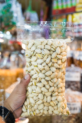 Roasted pistachio seeds with shell in a package on hand