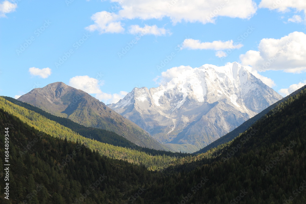 Fototapeta premium Majestic snow-capped mountain peaks pierce a clear blue sky Yala Snow Mountain Sichuan, China