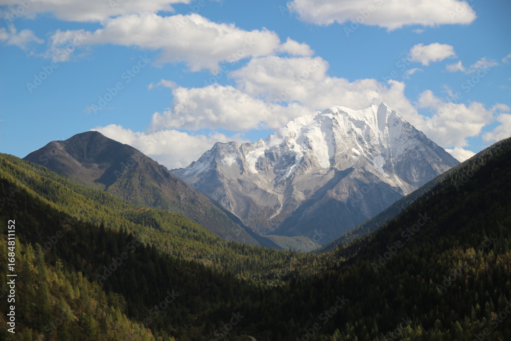 Fototapeta premium Majestic snow-capped mountain peaks pierce a clear blue sky Yala Snow Mountain Sichuan, China