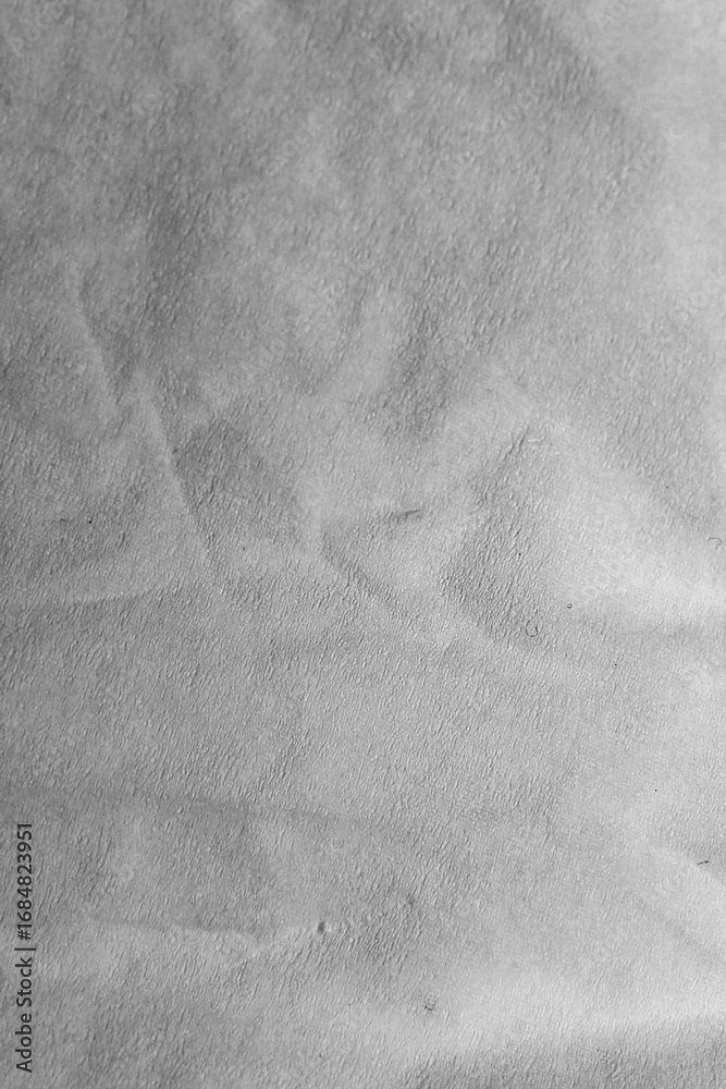 Naklejka premium Textured Gray Surface: A high-angle shot presents a textured gray surface, showcasing subtle patterns and gradients that create a visually captivating display of tone and depth.