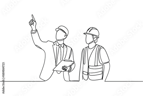 Two construction workers in hard hats discussing plans at a site