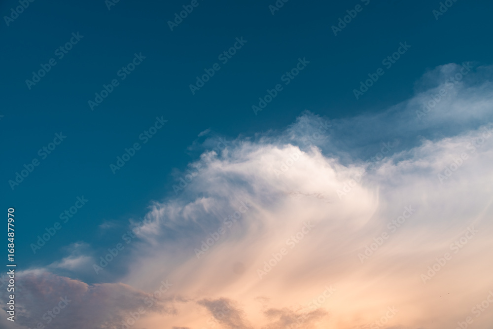 Obraz premium Dramatic summer clouds float peacefully across the vast blue skies, cinematic cloudscape at sunset 4k wallpaper 