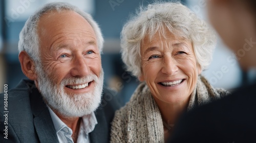 Smiling Senior Couple: A close-up shot of a smiling senior couple, exuding warmth and contentment. They are engaged in a lively conversation, their faces reflecting genuine happiness.