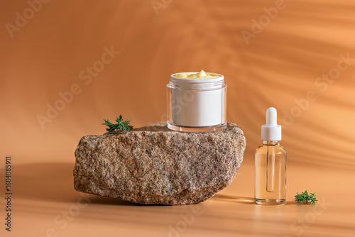 Cosmetic products in clean packaging on stone podium in sunlight on pastel peach background with shadows, collagen serum in dropper bottle and yellow retinol cream in jar, mockup