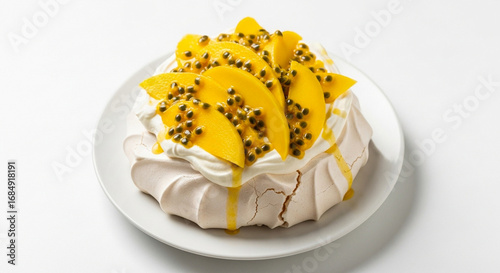 Pavlova dessert with whipped cream, mango slices, and passion fruit seeds on a white plate.