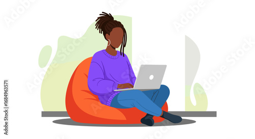 Young Black woman comfortably working on her laptop from a bean bag chair. Ideal for remote work, freelance, online education, and digital lifestyle concepts.