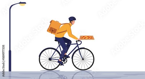 A male food delivery rider on a bicycle, carrying a large insulated bag and a pizza box, passing a street lamp.