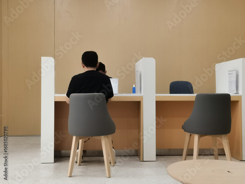 Schilderij op canvas Customers at a minimalist service counter with modern chairs.