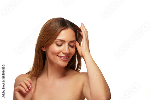 Wallpaper Mural A woman with long hair is smiling gently as she lightly touches her forehead, embodying a moment of joy and relaxation in her skincare routine. Torontodigital.ca