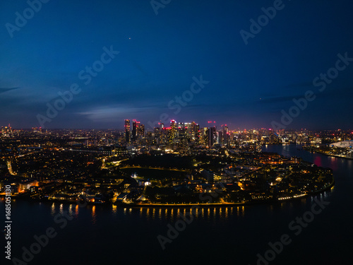 Wallpaper Mural A stunning view of London at night, featuring illuminated skyscrapers and the River Thames, with vibrant city life all around. Torontodigital.ca