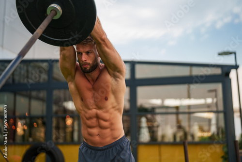 фотографія Caucasian fit man performing a barbell shoulder press exercise outdoors
