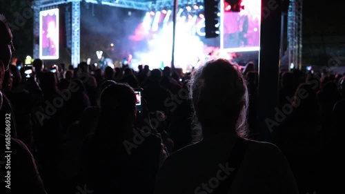 Silhouettes of people enjoying themselves at a concert