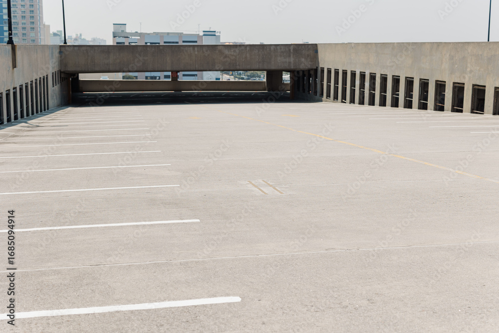 Fototapeta premium Open rooftop parking deck with empty spaces.