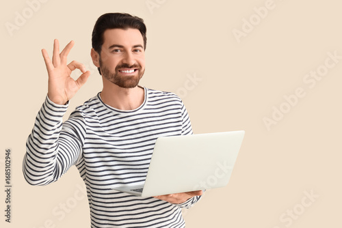 Young man with laptop showi...