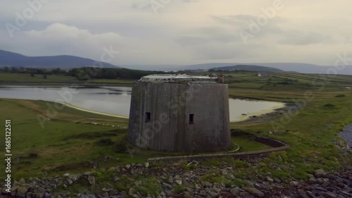 Fast, smooth aerial orbit of Aughinish Martello Tower, revealing Galway Bay, inlets, mountains, and the green coastline of County Clare
