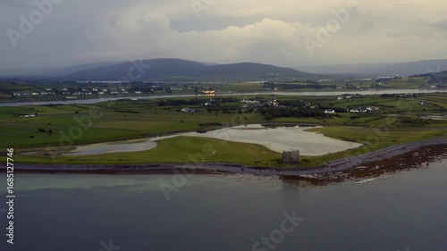 Static aerial view of County Clare coastline featuring a Martello Tower in the foreground and a scenic inlet