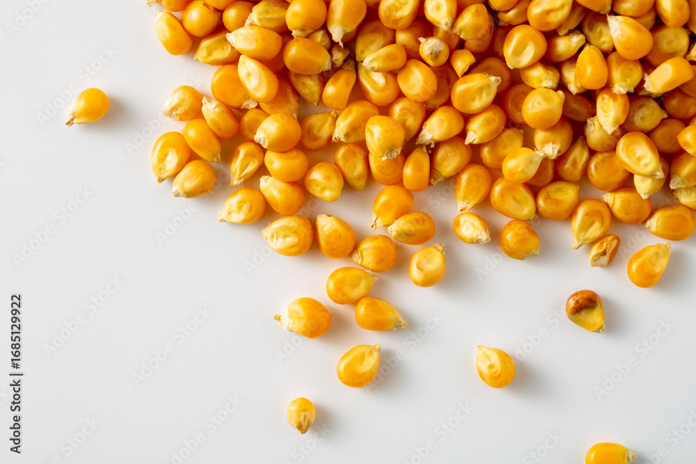 Fototapeta premium Yellow Corn Kernels on White Surface for Culinary Uses and Recipes