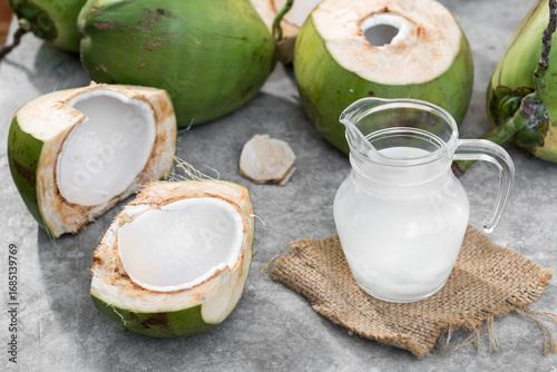 Fresh Coconuts with Coconut Water and Slices on a Rustic Surface