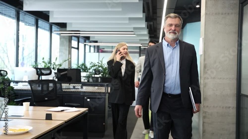 Wallpaper Mural A man in a suit is walking with two other people in a business setting Torontodigital.ca