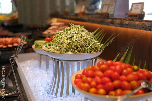Assorted fresh salads displayed on a buffet in individual containers at a catered event or celebration, receding perspective