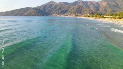  Woman swimming in sea in Golden beach at Thassos Island, Greece. Amazing beach with clear blue water. Aerial panoramic drone view from above, top view from drone. Summer holidays Europe

