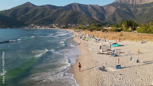  Woman swimming in sea in Golden beach at Thassos Island, Greece. Amazing beach with clear blue water. Aerial panoramic drone view from above, top view from drone. Summer holidays Europe
