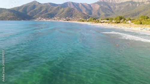  Woman swimming in sea in Golden beach at Thassos Island, Greece. Amazing beach with clear blue water. Aerial panoramic drone view from above, top view from drone. Summer holidays Europe
