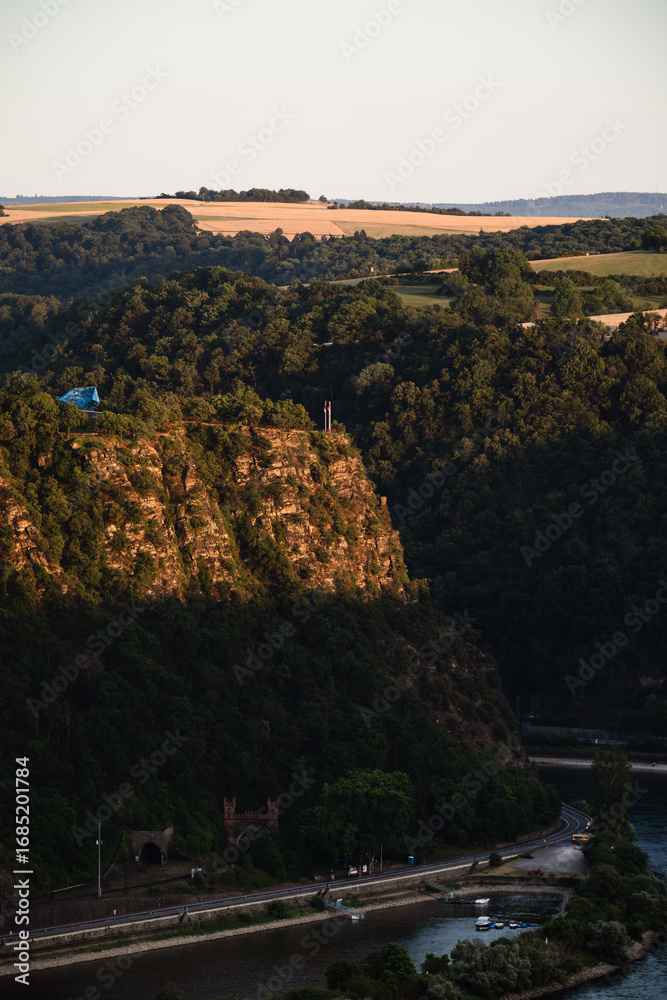 Obraz premium Blick vom Dreiburgenblick in Richtung Loreley mit Gläsernem Felsen (Mythoshalle), Juli 2025