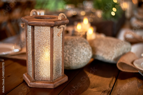 Handmade wooden lanterns and large stones in the d cor of the wedding table in the style of Vikings and warriors. Tree.