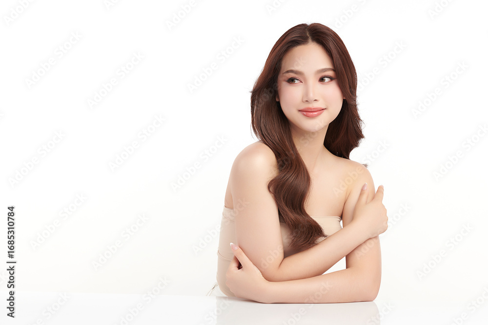 Obraz premium A beautiful young Asian woman with clean, fresh skin against a white background. Skincare, facial treatment, cosmetology, beauty, and spa. An elegant portrait of an Asian woman.