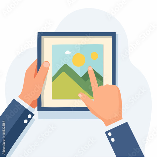 Hands Pointing To Framed Picture Of Mountains