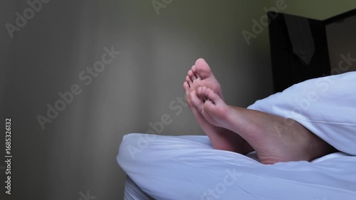 teenager's legs on hotel bed	