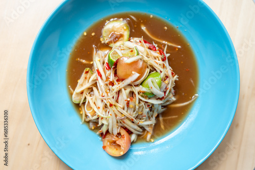 Top view close up Authentic Thai Papaya Salad in a Blue Ceramic Bowl