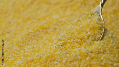 Macro Texture Of Raw Corn Grits Pour Out Of Spoon Slow Motion