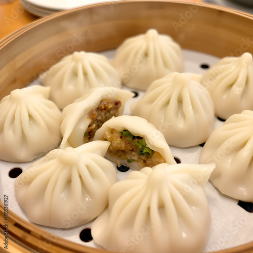 Steamed dumplings are arranged in a steamer, with steam rising and a variety of fillings